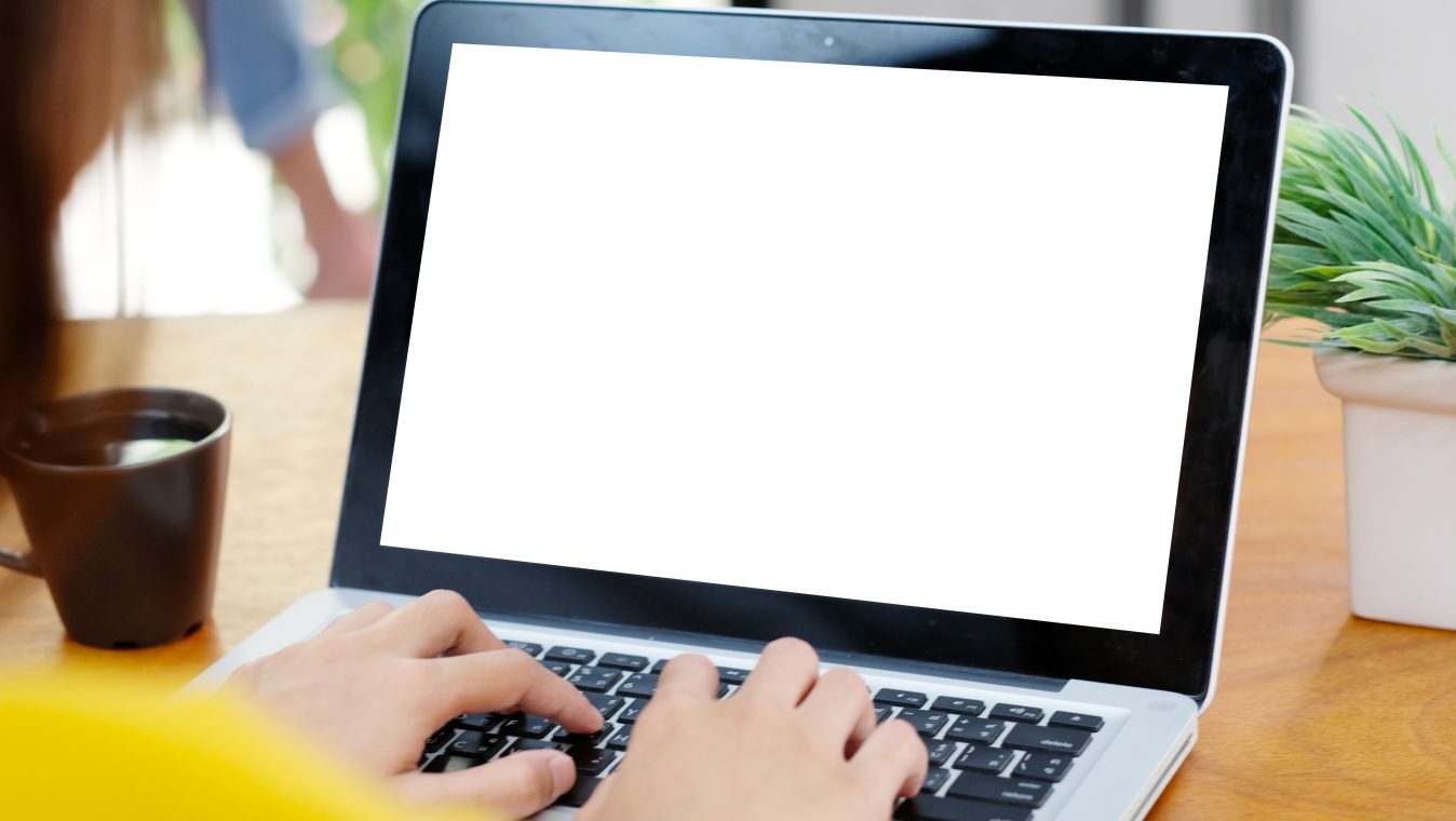 Woman hands typing laptop computer with blank screen for mock up
